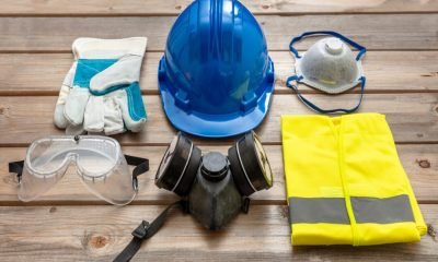 Work safety protection equipment. Industrial protective gear on wooden background. Construction site health and safety concept