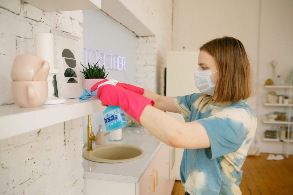 woman wearing face mask while cleaning